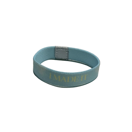 Blue wristband with 'I MADE IT' text on a white background