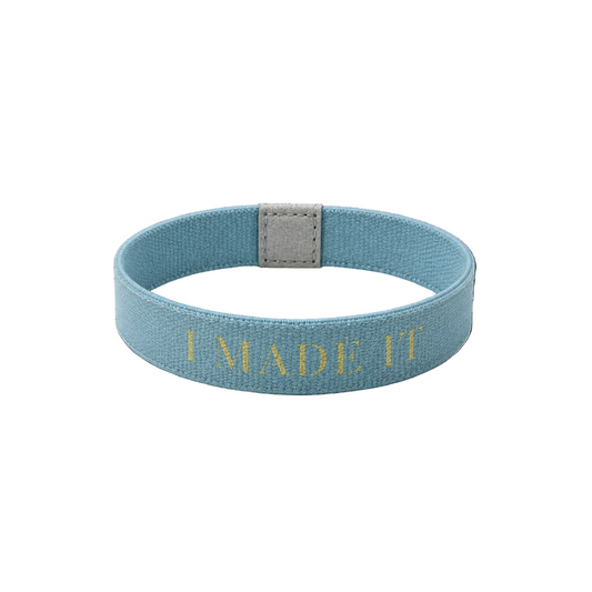 Blue wristband with 'I MADE IT' text on a white background