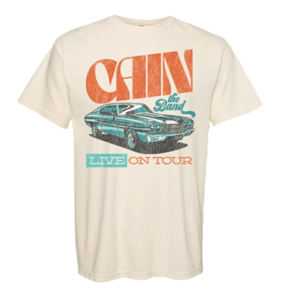 A beige t-shirt featuring text and an illustration of a vintage car. The text includes &